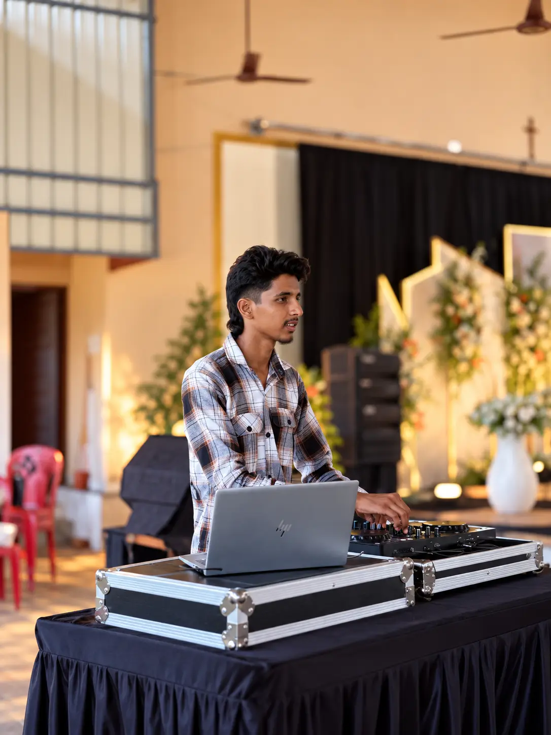 DJ Rev setting up his laptop and controller in a church hall