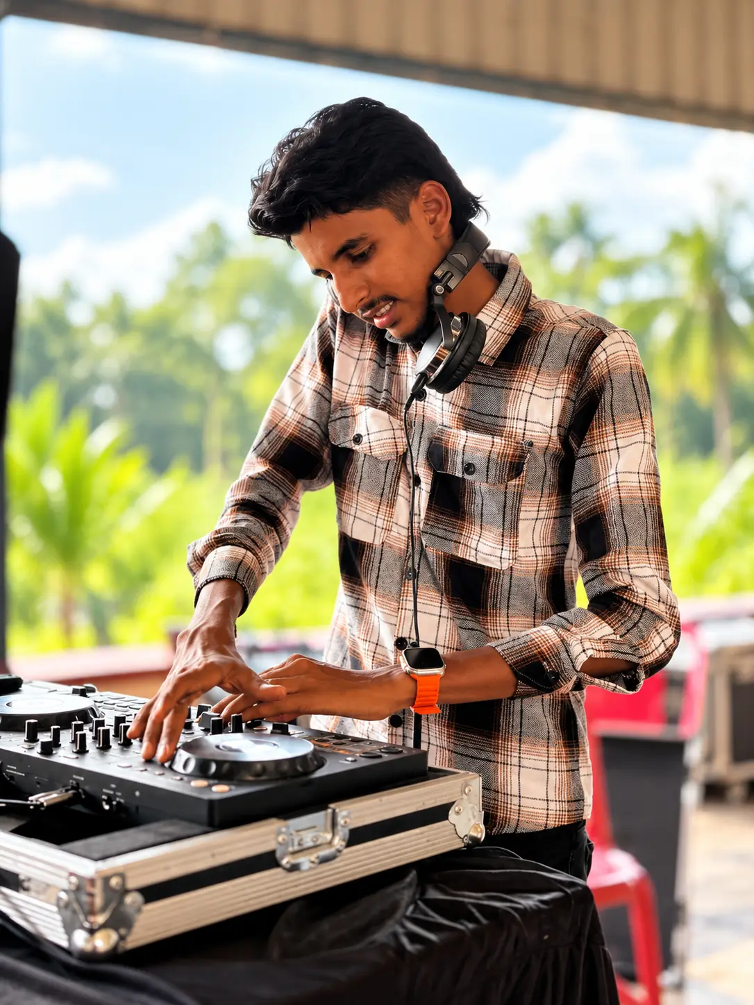 Close-up of DJ Rev working the controller on a rooftop